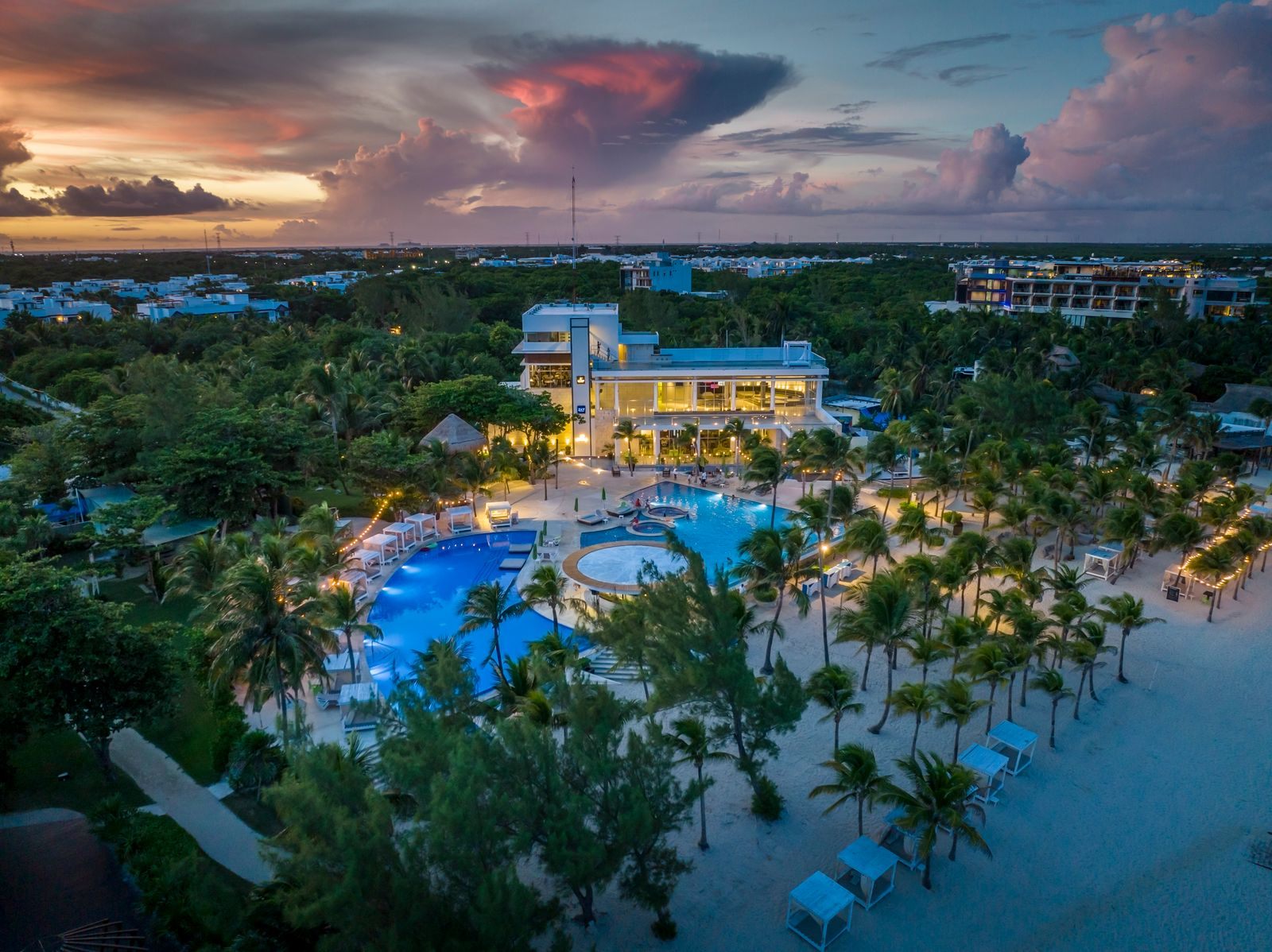 Beach resort and palm trees at sunset in Playa del Carmen, Mexico